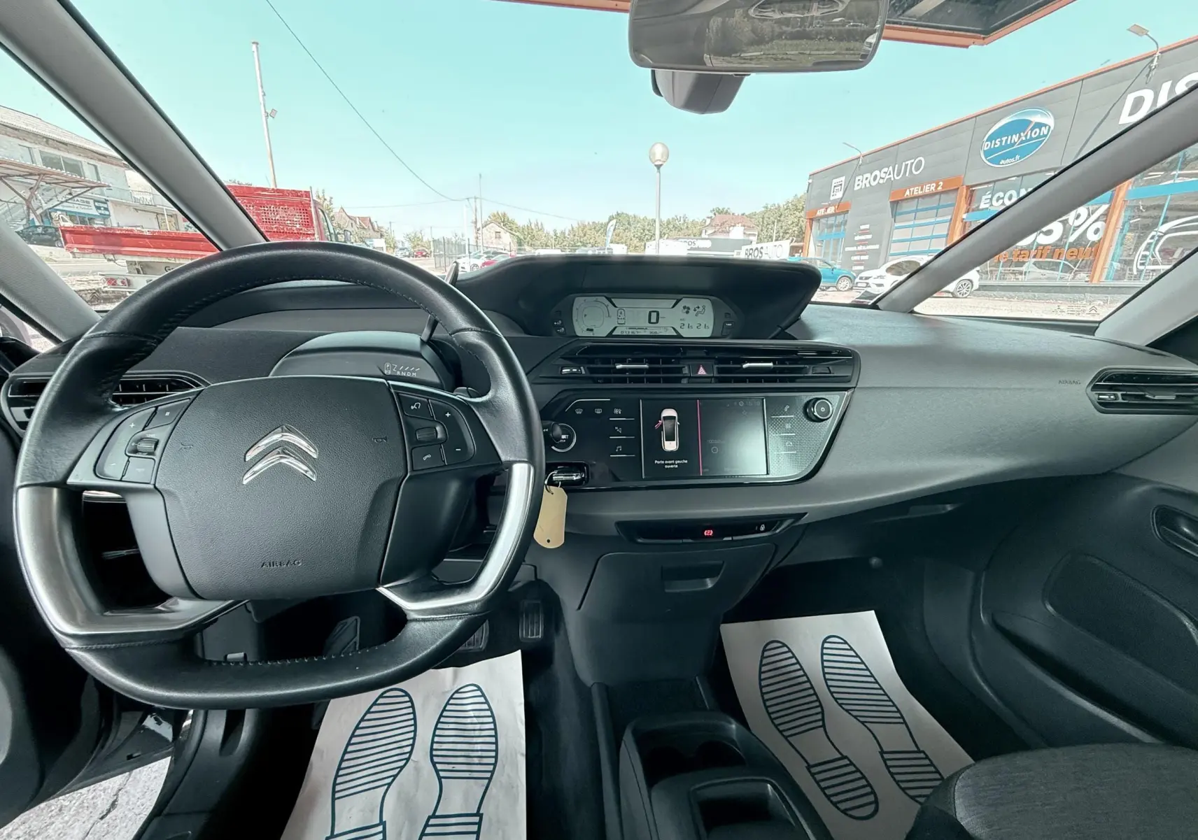 Vue intérieure avant du tableau de bord et volant noir d'une Citroën C4 Spacetourer avec écran tactile et affichage numérique.