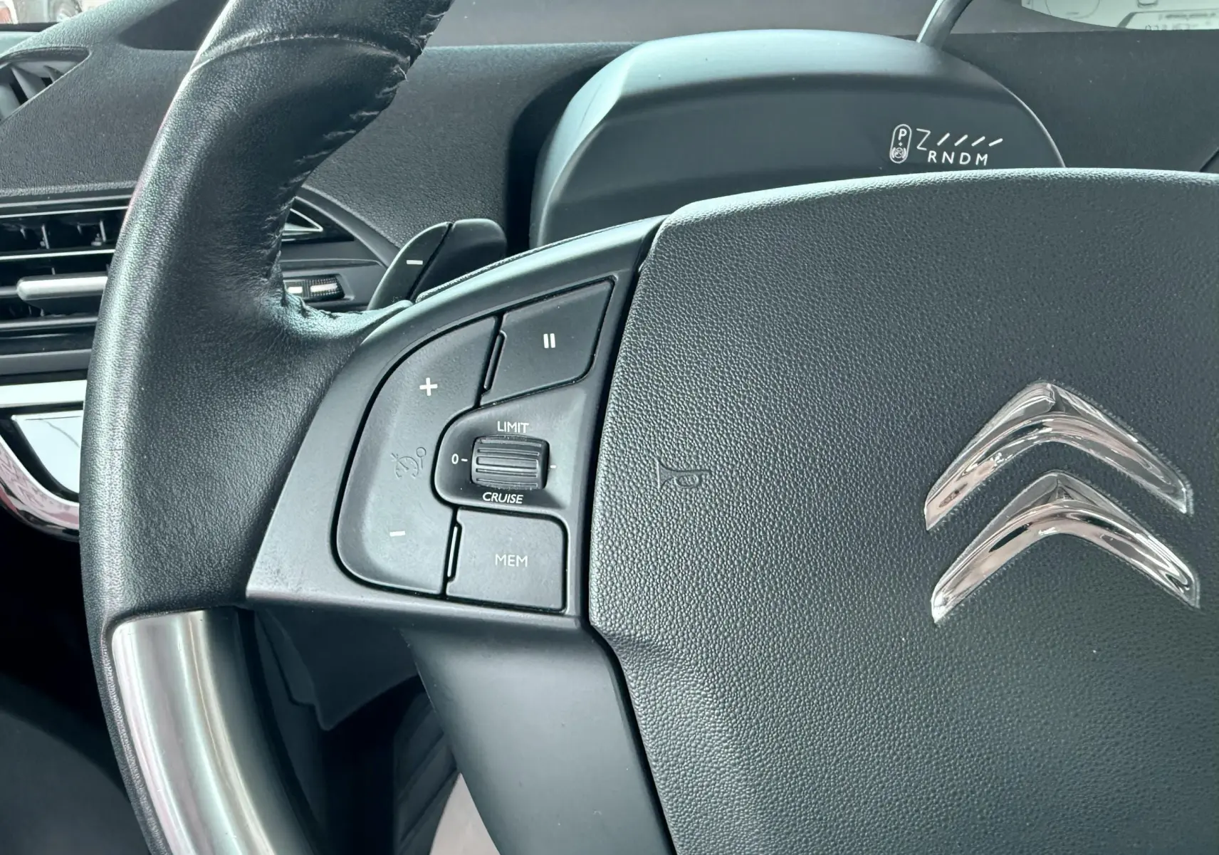 Gros plan sur le volant noir de la Citroën C4 Spacetourer 2019, avec commandes intégrées et logo chromé visible.