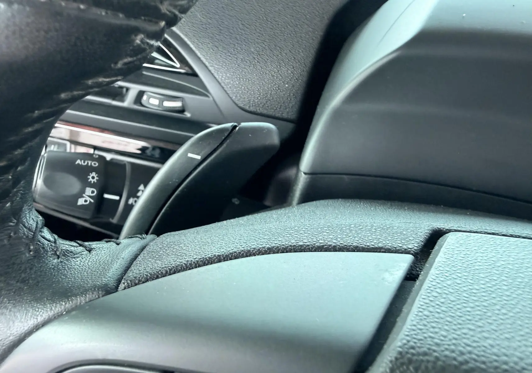 Gros plan sur le volant noir et la commande des phares du tableau de bord d’une Citroën C4 Spacetourer 2019.