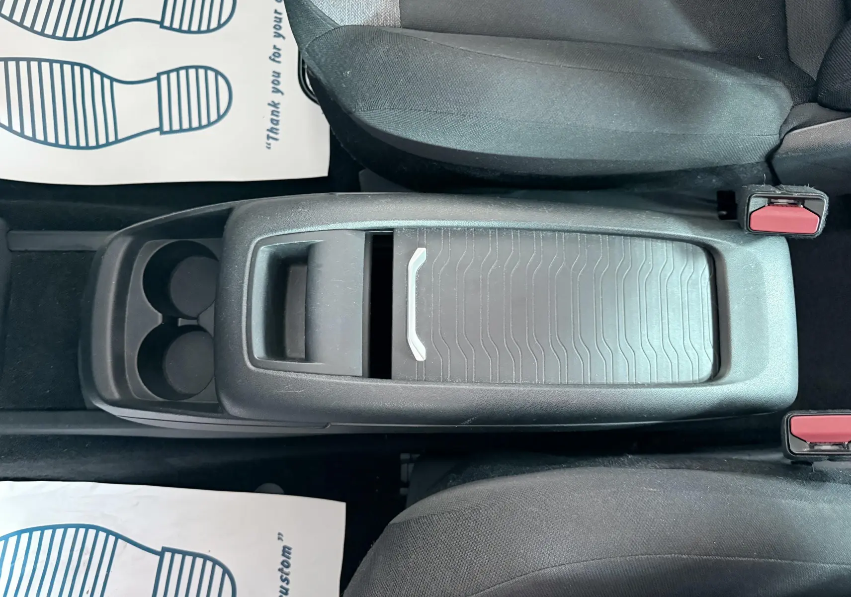 Vue plongeante sur la console centrale noire avec porte-gobelets et accoudoir coulissant du Citroën C4 Spacetourer 2019.