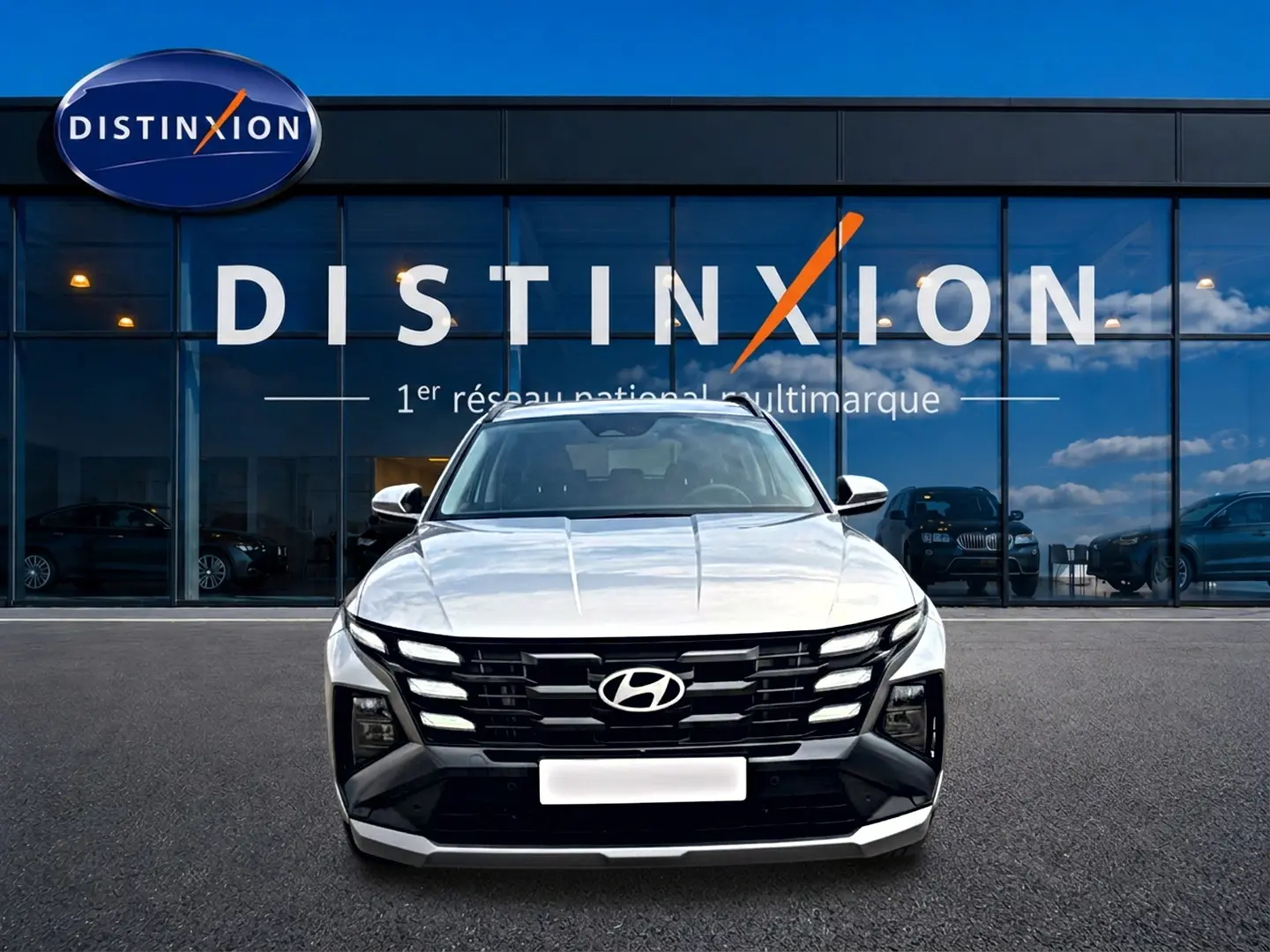 Vue frontale du Hyundai Tucson gris shimmering 2026 avec calandre noire distinctive et feux LED intégrés.