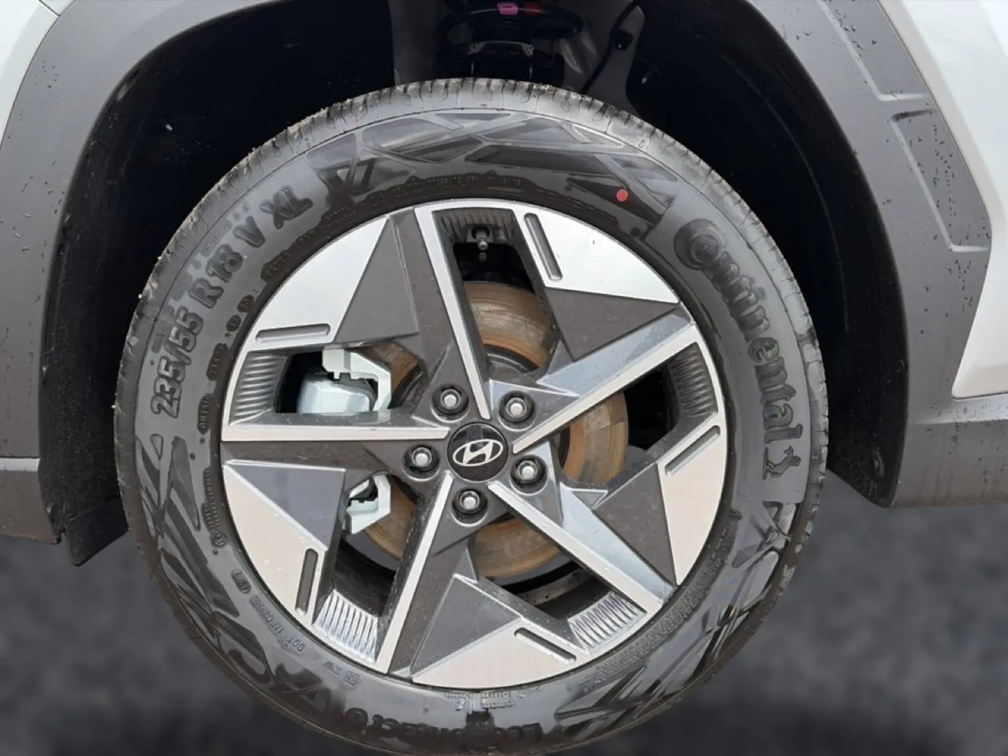 Gros plan sur la jante alu 18 pouces gris et noir du Hyundai Tucson 2026, avec logo Hyundai visible au centre.