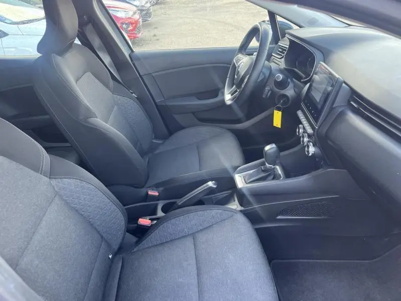 Intérieur avant de la Renault Clio 1.6 E-Tech 2021, sièges tissu noir avec motifs, tableau de bord et console centrale visibles.