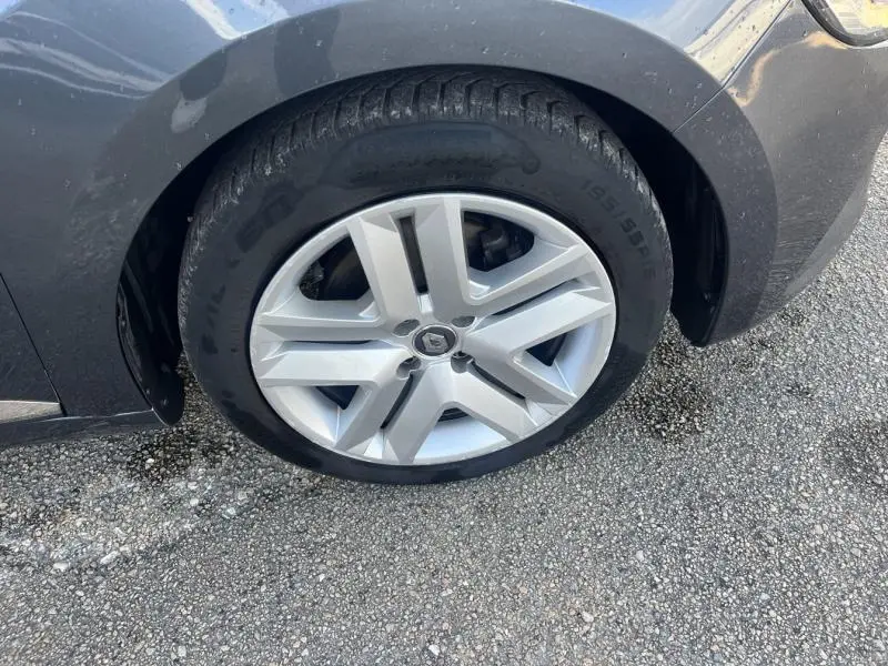 Gros plan sur la roue avant gauche de la Renault Clio gris Titanium avec jante alliage distinctive et partie de l'aile avant visible.