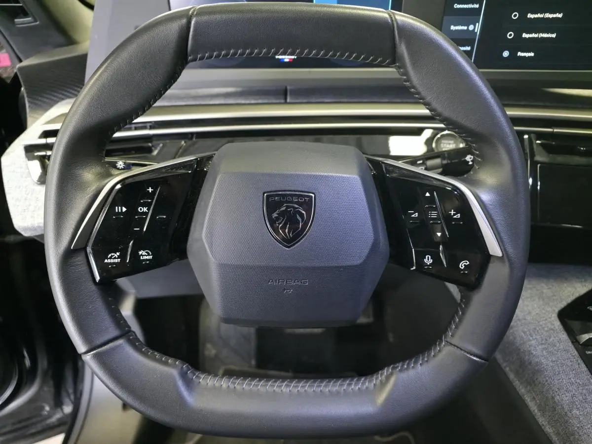 Volant compact noir de Peugeot 3008 2025 avec commandes tactiles intégrées et logo lion central.