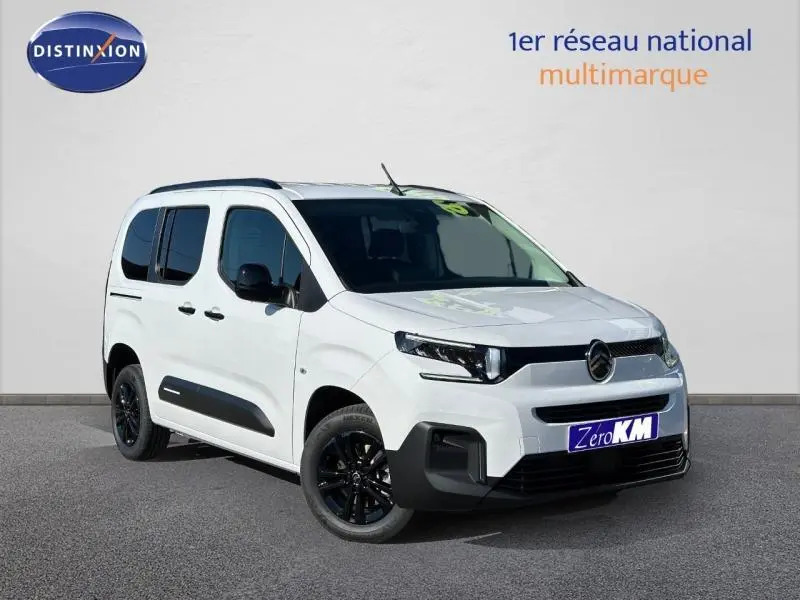 Vue 3/4 avant droite d'un Citroën Berlingo blanc 2025 avec jantes noires et protections latérales noires.