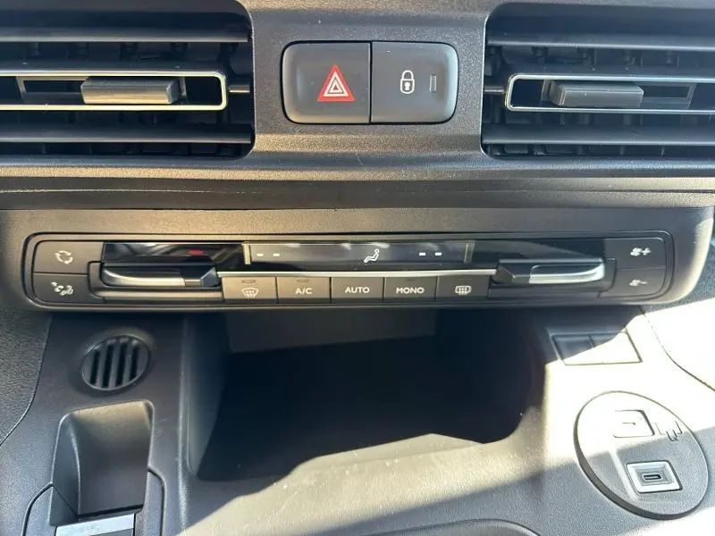 Vue rapprochée du tableau de bord noir du Citroën Berlingo 2025 montrant les commandes de climatisation et les aérateurs.