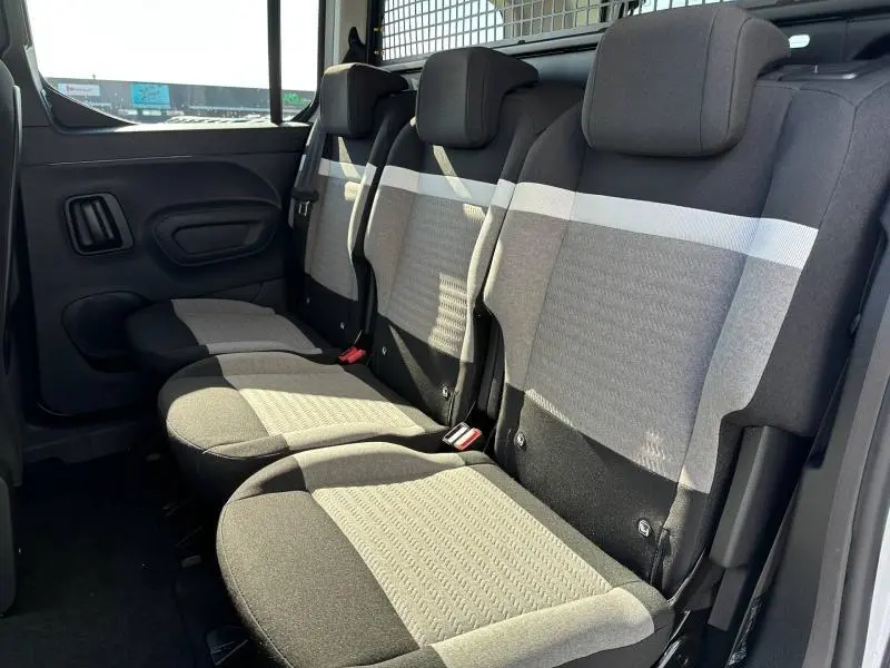 Vue latérale intérieure montrant la banquette arrière grise et noire du Citroën Berlingo M 2025 avec appuie-têtes et ceintures.