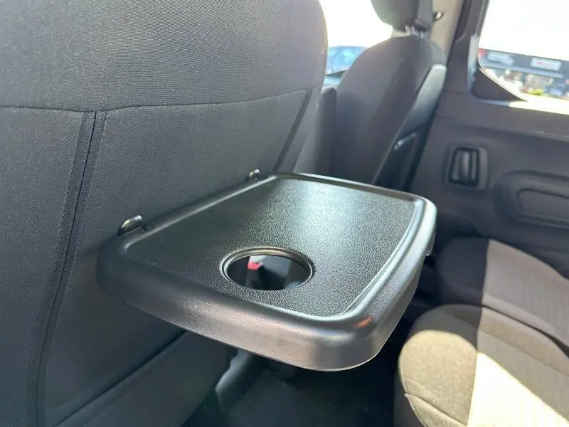 Tablette rabattable noire avec porte-gobelet côté gauche à l'arrière du Citroën Berlingo 2025, intérieur gris.