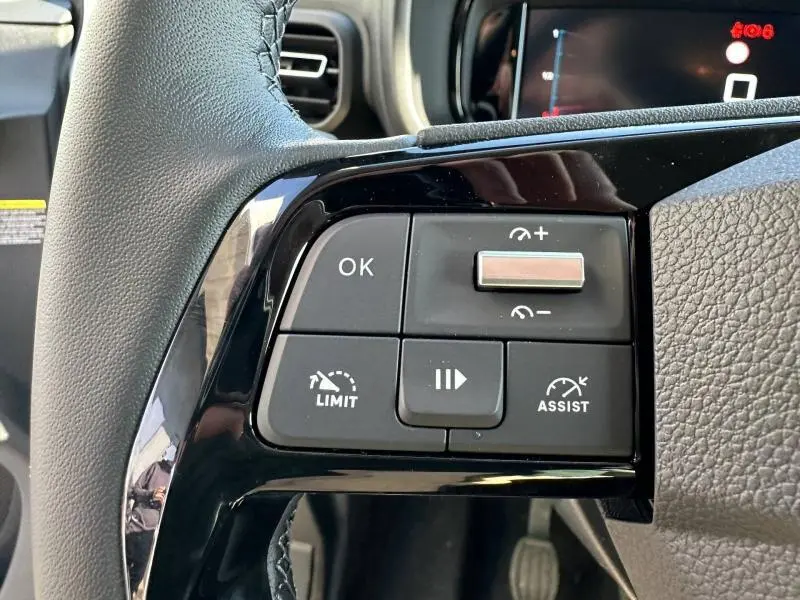 Gros plan sur les commandes noires du volant multifonction du Citroën Berlingo 2025, finition Urban Grey.