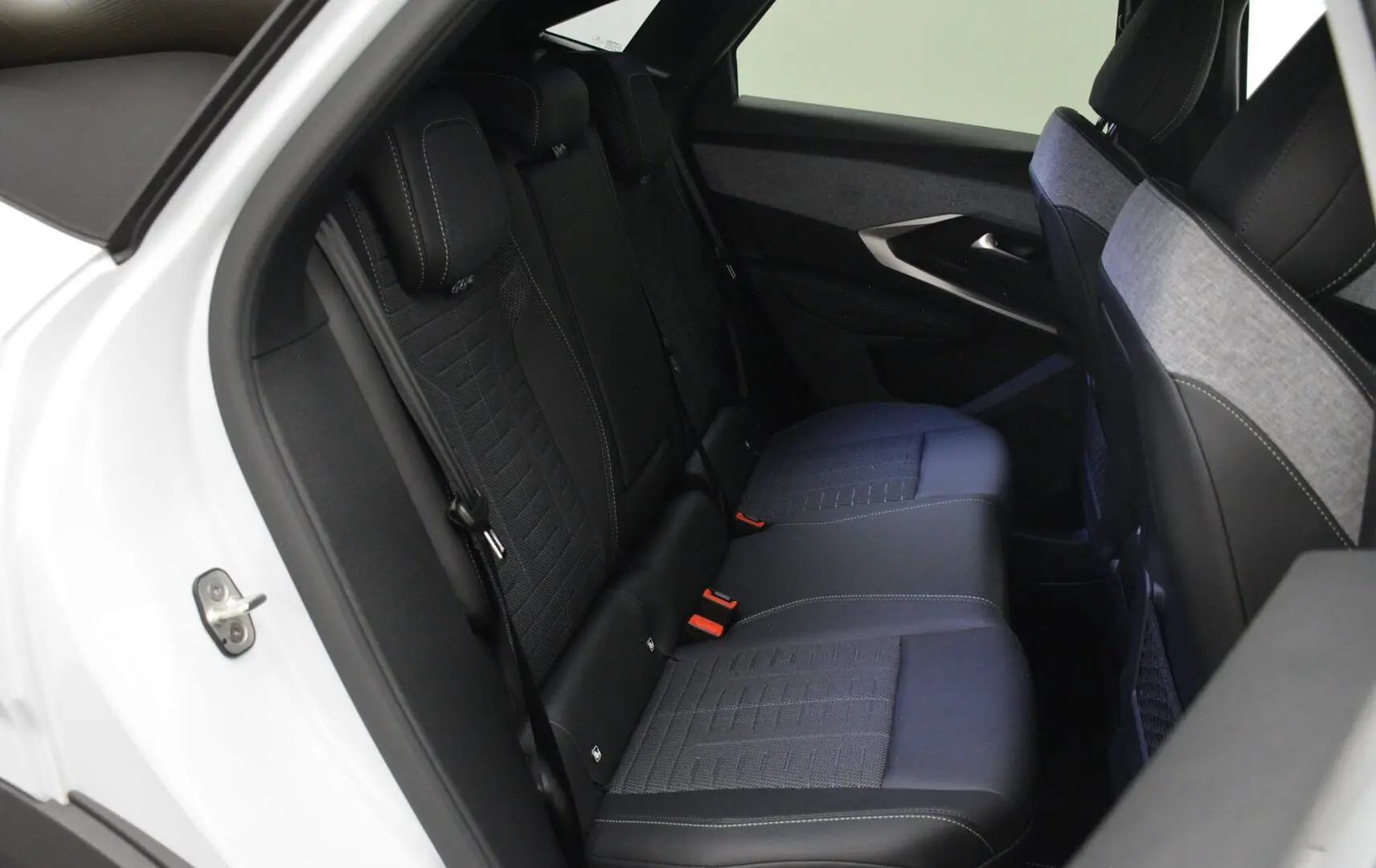 Vue intérieure côté gauche montrant la banquette arrière noire et grise du Peugeot 3008 blanc Okenite 2026.