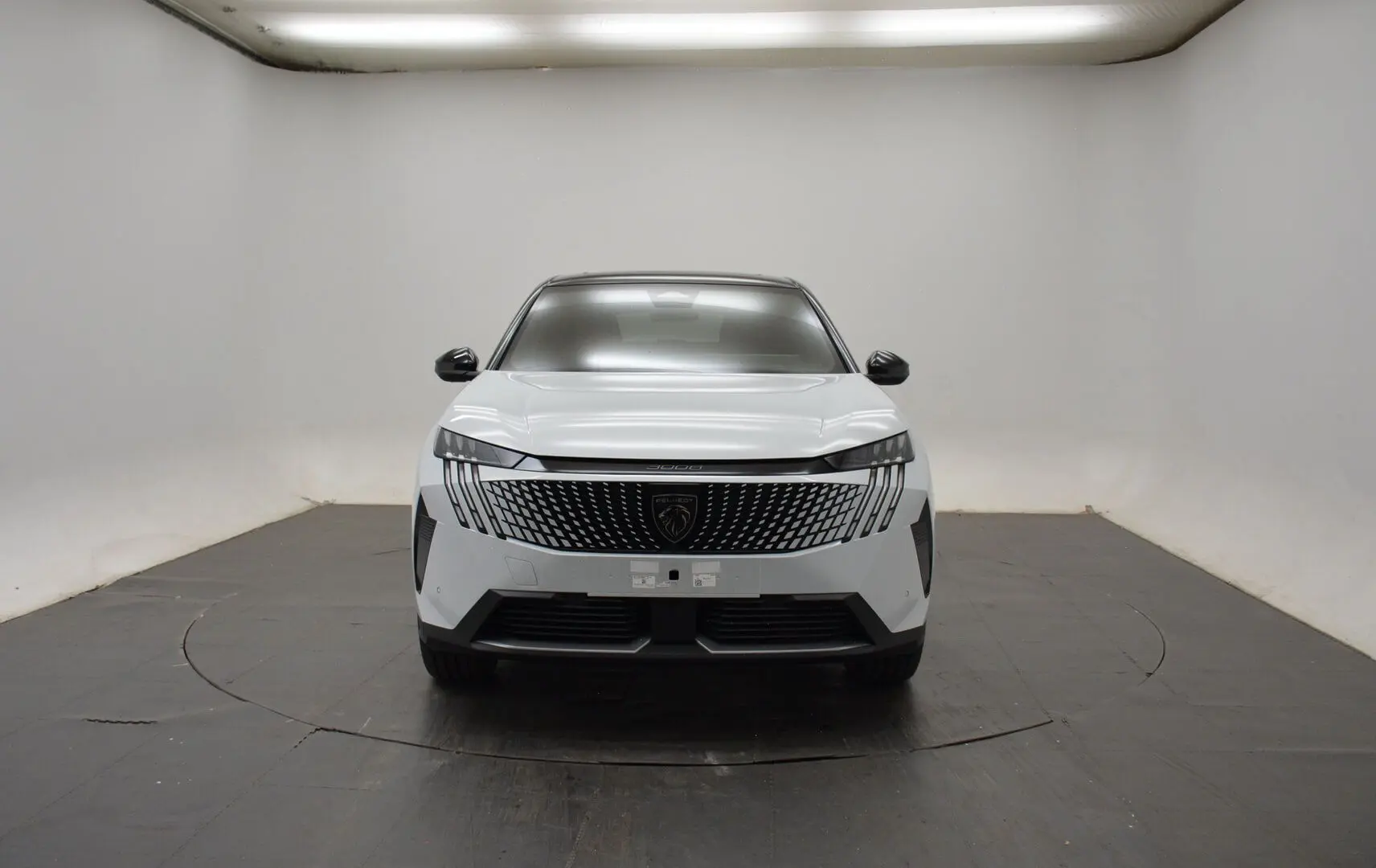 Vue frontale d’un Peugeot 3008 III Hybrid blanc Okenite avec calandre distinctive et toit noir panoramique.