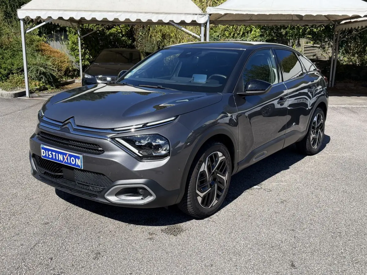 Citroën C4 PureTech 130 S&S Shine gris foncé vue 3/4 avant droit sur parking ensoleillé.