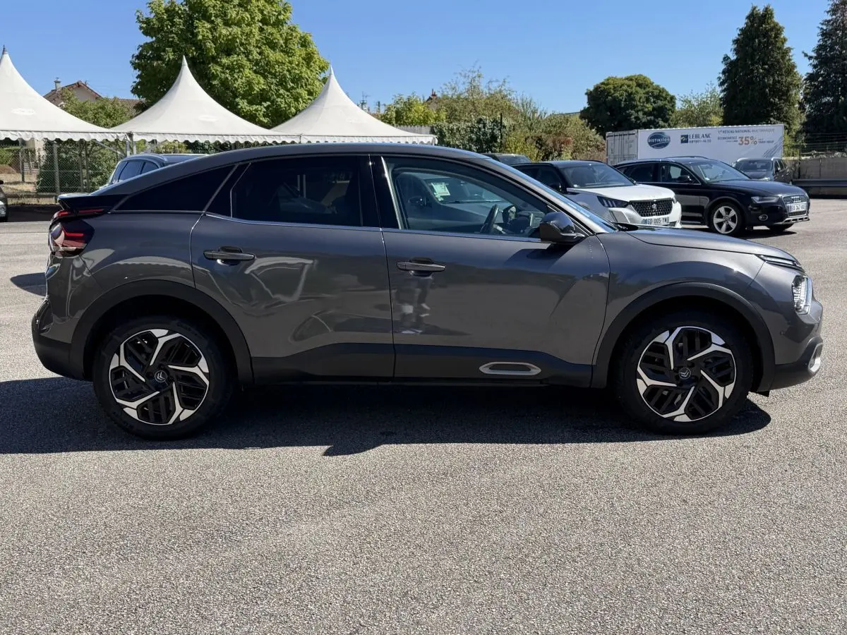 Profil droit d'une Citroën C4 PureTech 130 S&S Shine gris foncé, avec jantes alliage et lignes fluides modernes.