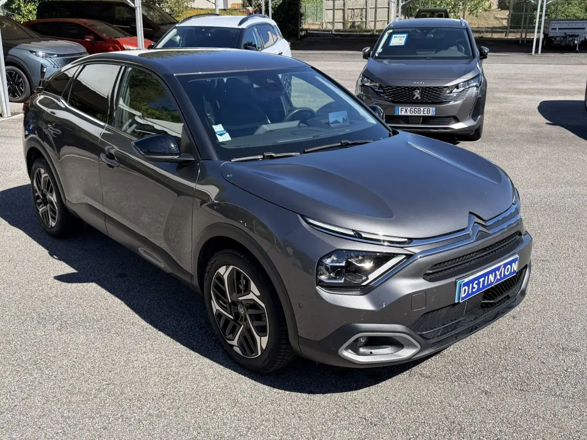 Citroën C4 PureTech 130 S&S Shine gris foncé vue 3/4 avant avec signature lumineuse distinctive et jantes stylées.