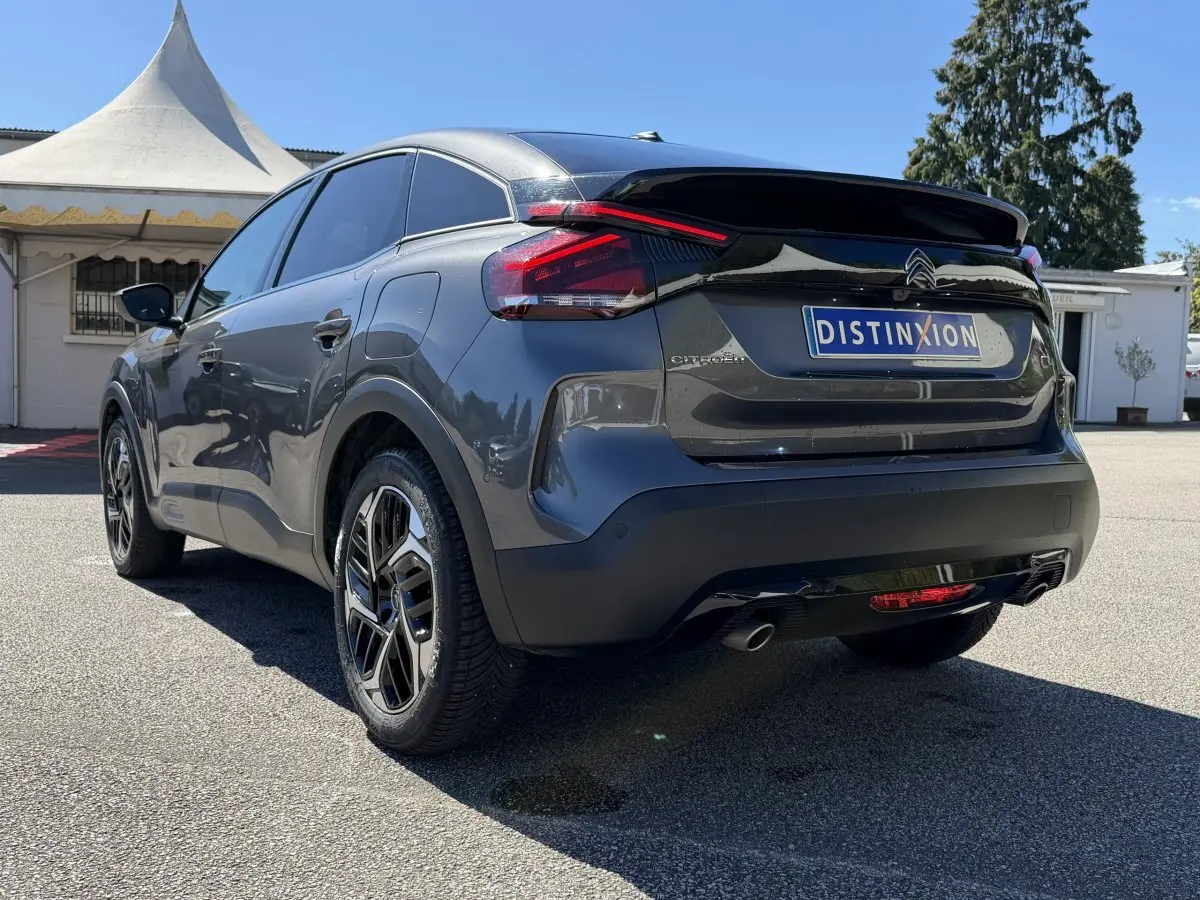 Vue 3/4 arrière droite d'une Citroën C4 PureTech 130 S&S Shine gris foncé avec feux LED et jantes alliage.
