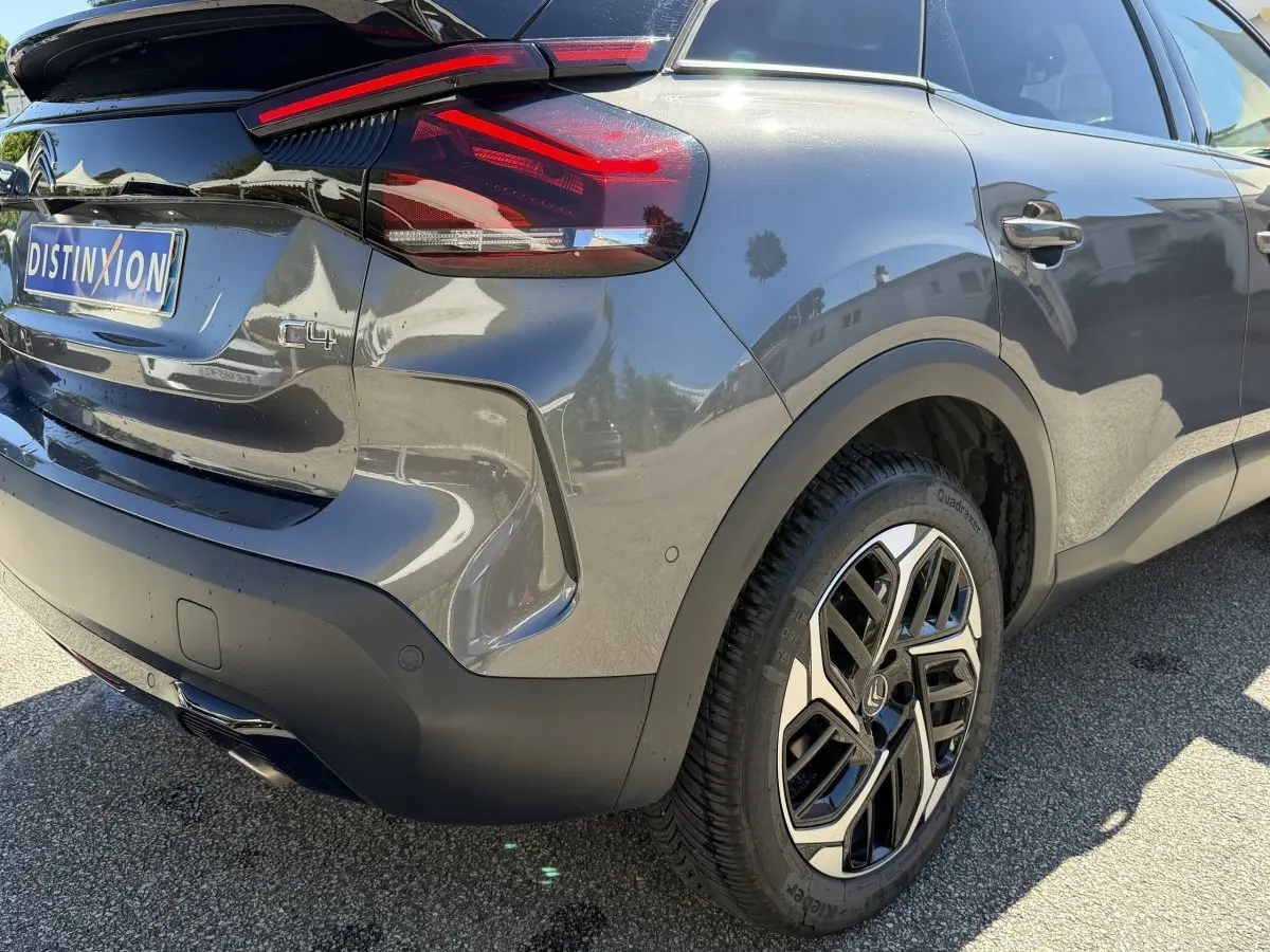 Vue 3/4 arrière droite d'une Citroën C4 gris foncé avec feux arrière LED et jante alliage au design moderne.