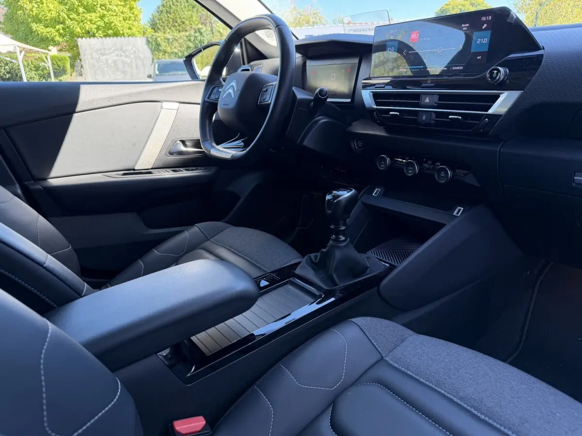 Intérieur avant droit de la Citroën C4 PureTech 130 S&S Shine 2022, avec tableau de bord numérique et volant cuir noir.