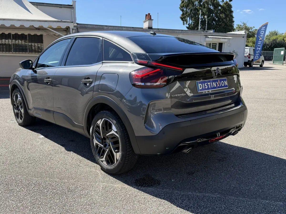 Vue 3/4 arrière droite d'une Citroën C4 PureTech 130 gris foncé avec feux arrière LED et jantes alliage noires.
