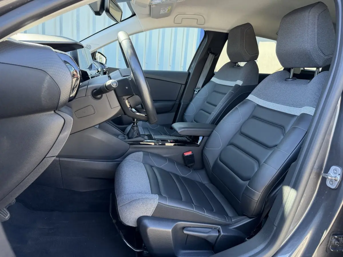 Vue intérieure côté conducteur de la Citroën C4 PureTech 130 S&S Shine 2022, sièges cuir et tissu gris foncé.