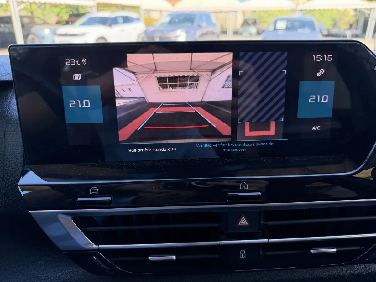 Écran tactile central de la Citroën C4 gris foncé montrant la caméra de recul et la climatisation à 21°C.