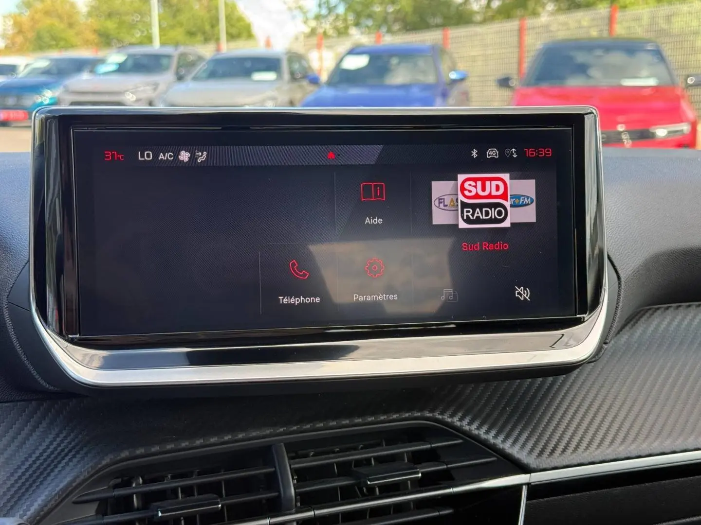 Écran tactile central de la Peugeot 208 1.2 100ch Allure, affichant la radio Sud Radio en extérieur lumineux.