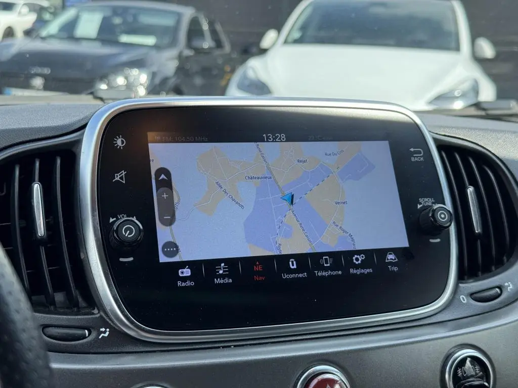 Écran tactile 7'' du système Uconnect avec navigation affichée, tableau de bord gris satiné de l'Abarth 500 blanc.