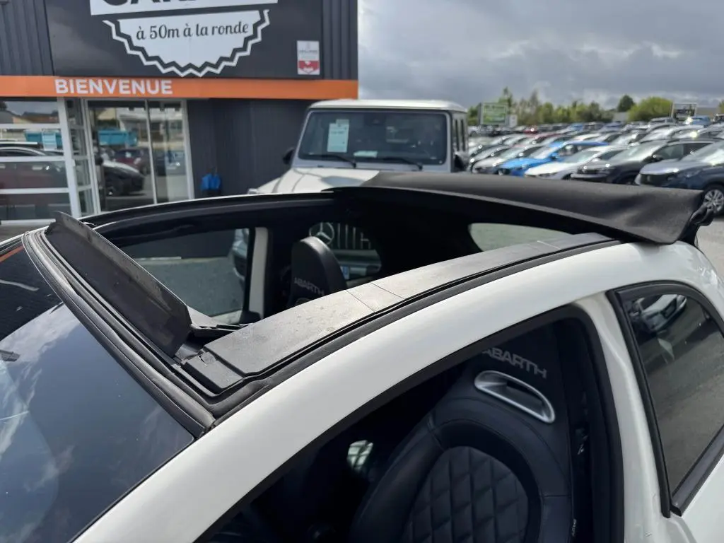 Toit ouvrant ouvert vu de dessus sur l'ABARTH 500 blanc avec sièges sport en cuir marqués ABARTH.