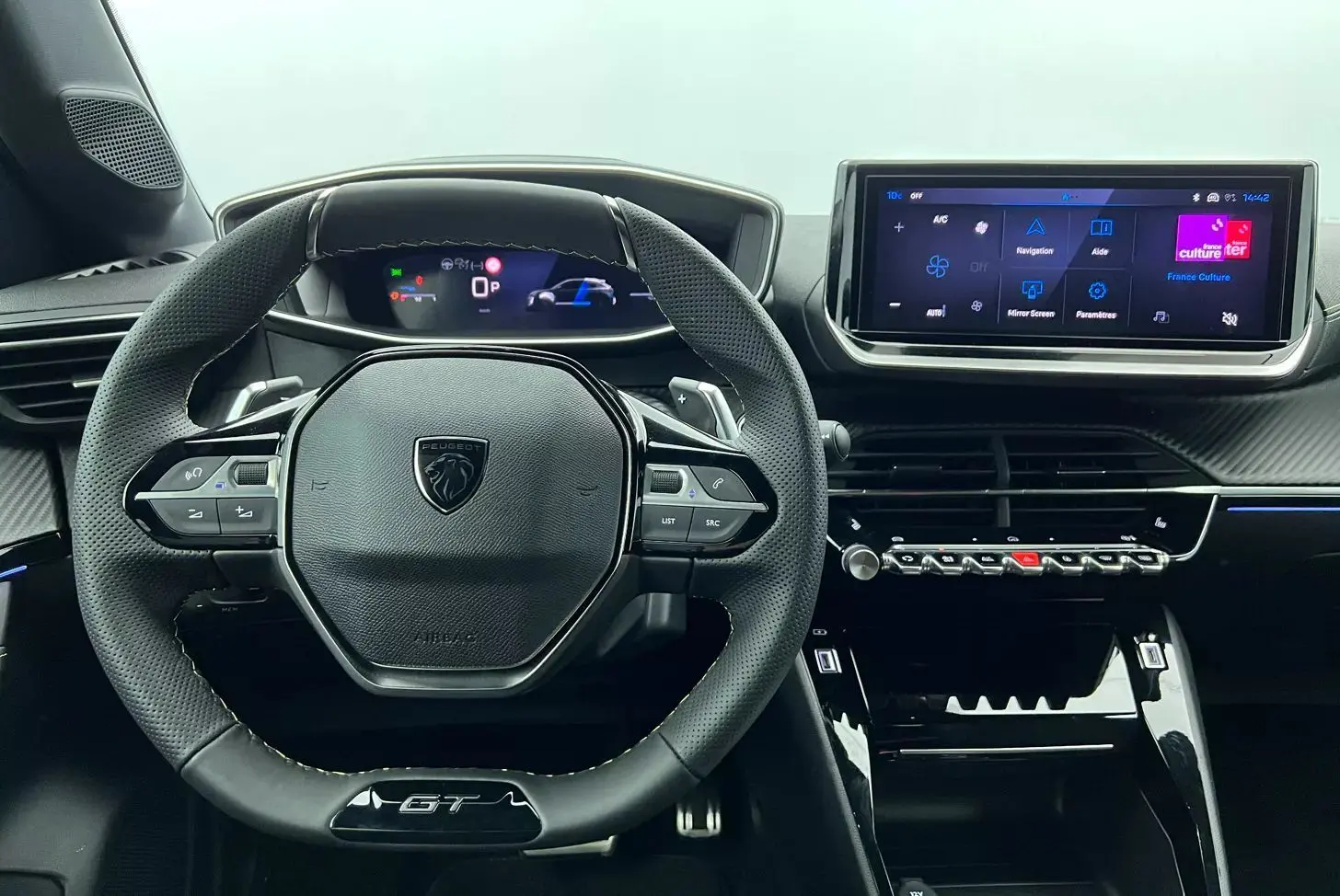 Intérieur noir du Peugeot 208 1.2 HYBRID 136 GT 2025, vue centrée sur le volant compact et l’écran tactile moderne.