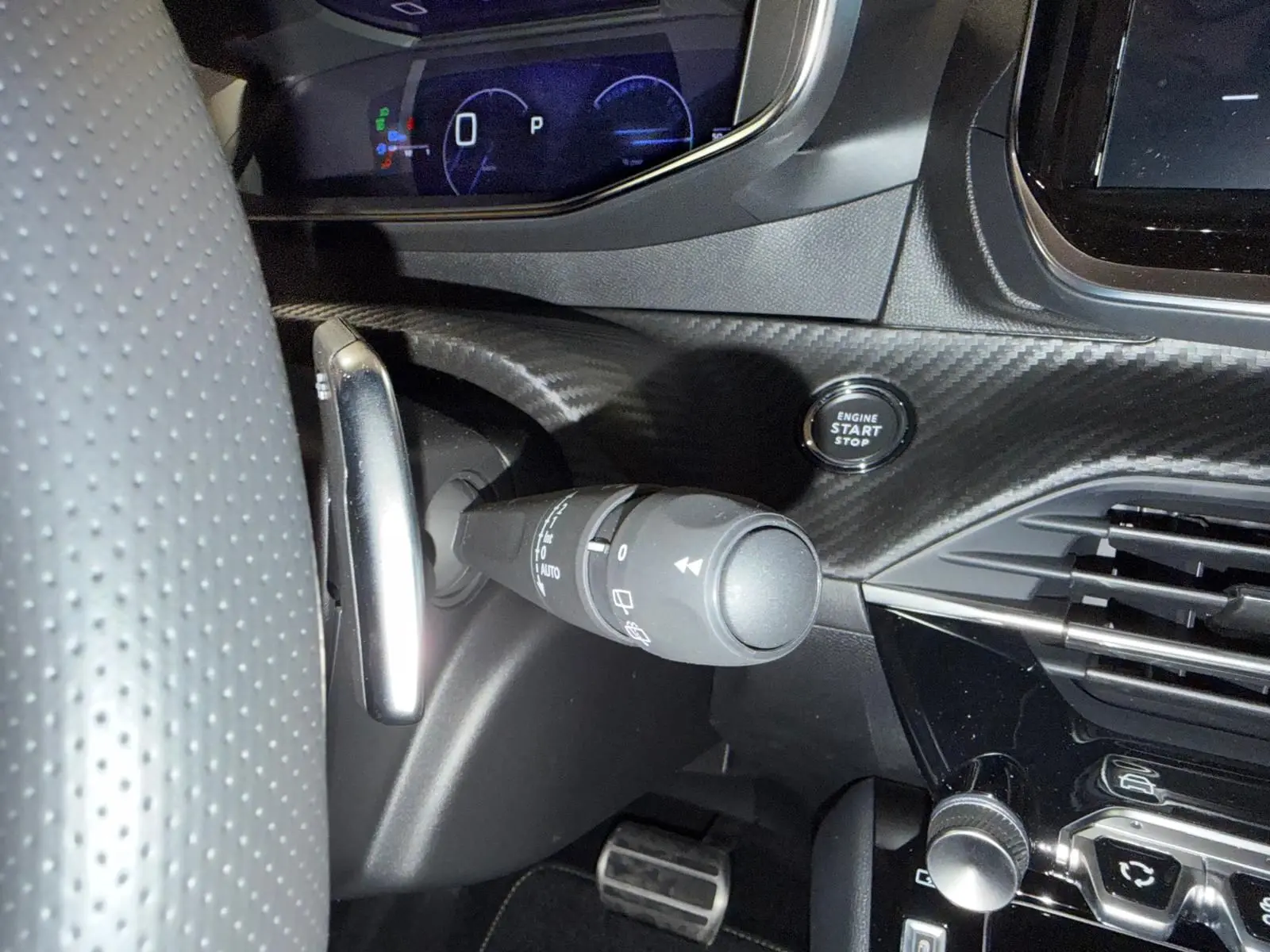 Gros plan sur la commande d’essuie-glace et bouton start du tableau de bord noir à effet carbone de la Peugeot 208 1.2 Hybrid 136 GT.