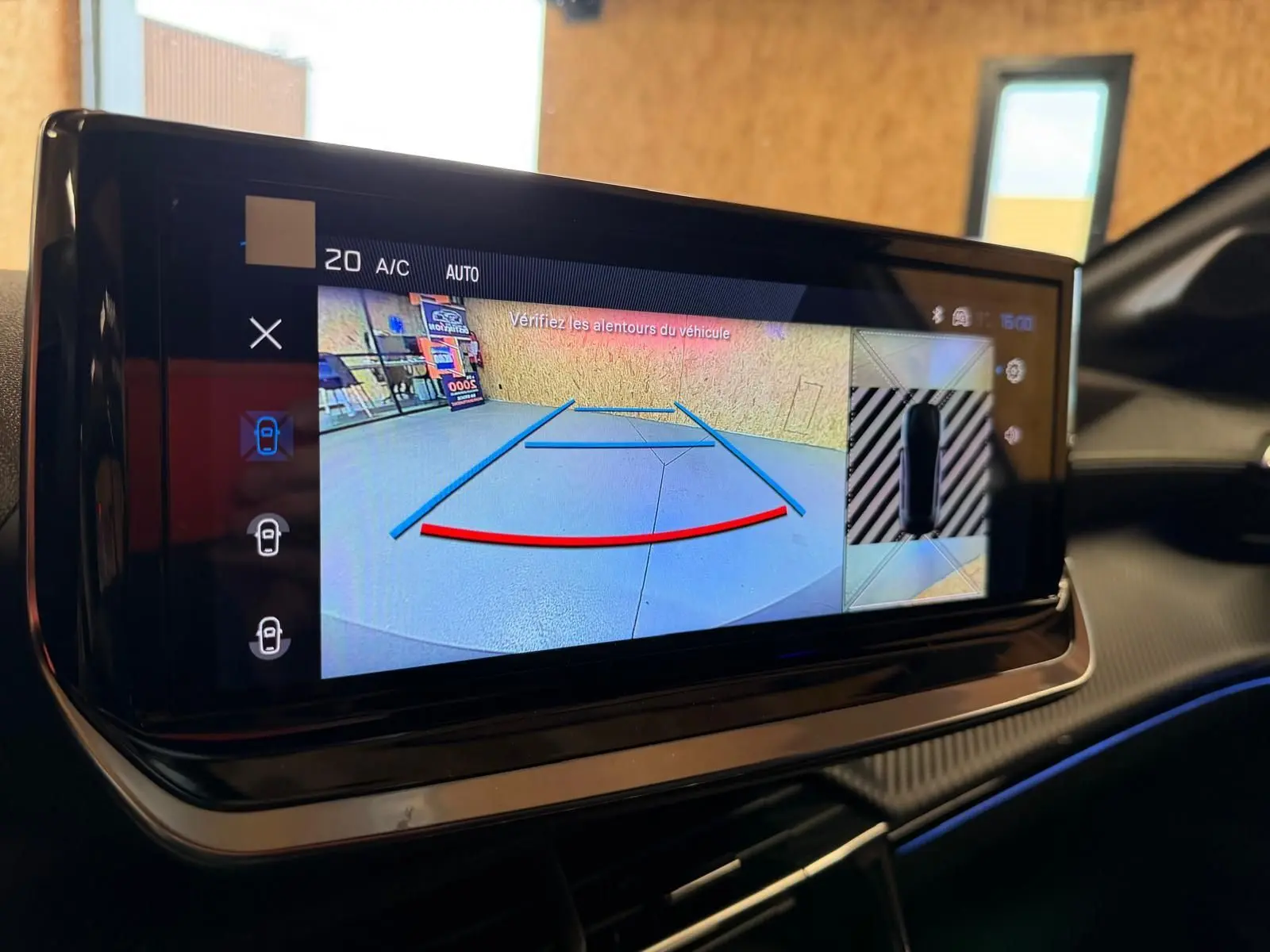 Écran tactile intérieur du Peugeot 208 1.2 Hybrid 136 GT montrant la caméra de recul avec guidage dynamique.