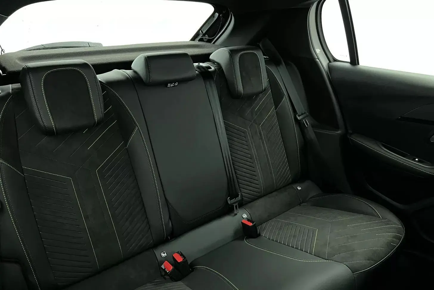 Vue intérieure arrière côté droit montrant les sièges arrière noirs en tissu avec surpiqûres contrastantes du Peugeot 208 1.2 Hybrid 136 GT.