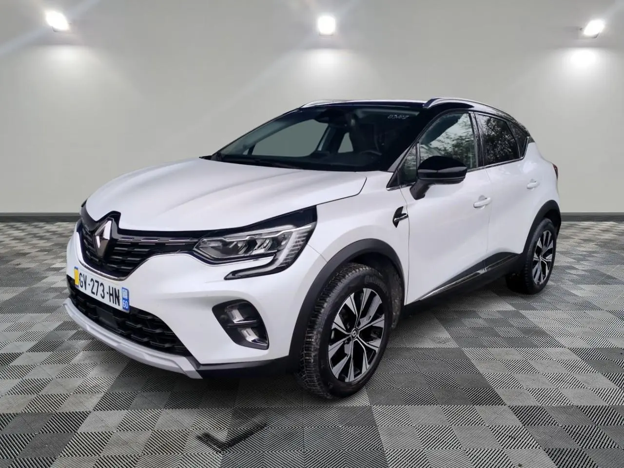 Renault Captur blanc vue 3/4 avant droit avec toit noir et jantes alliage bicolores.