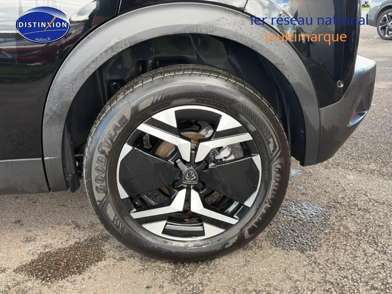 Gros plan sur la roue arrière droite noire d'une Peugeot 2008 1.2 100 allure avec jante alu bicolore.