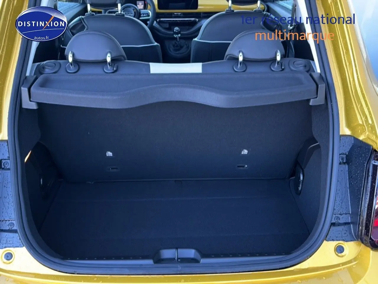 Coffre ouvert vu de l'arrière d'une FIAT 500 Yellow Gold Métal avec banquette rabattable et cache-bagages.