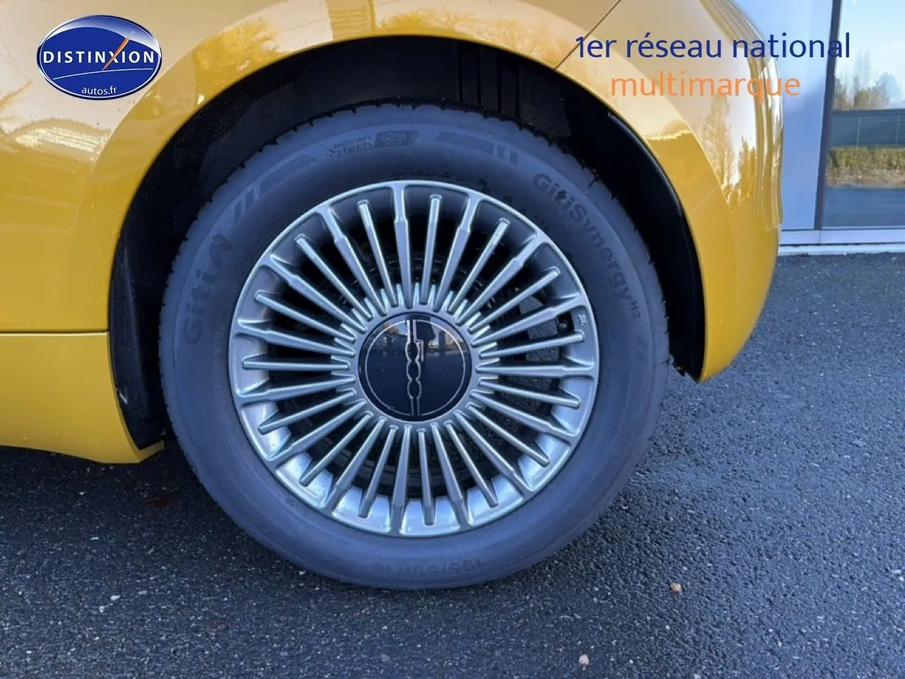 Gros plan sur la roue arrière droite d'une FIAT 500 Yellow Gold Métal avec jante alu au design rayonné.