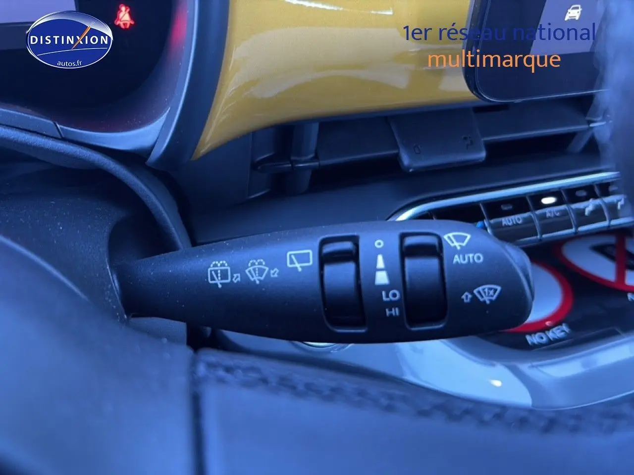 Gros plan sur la commande des essuie-glaces dans l’habitacle d’une Fiat 500 Yellow Gold Métal, avec tableau de bord partiellement visible.