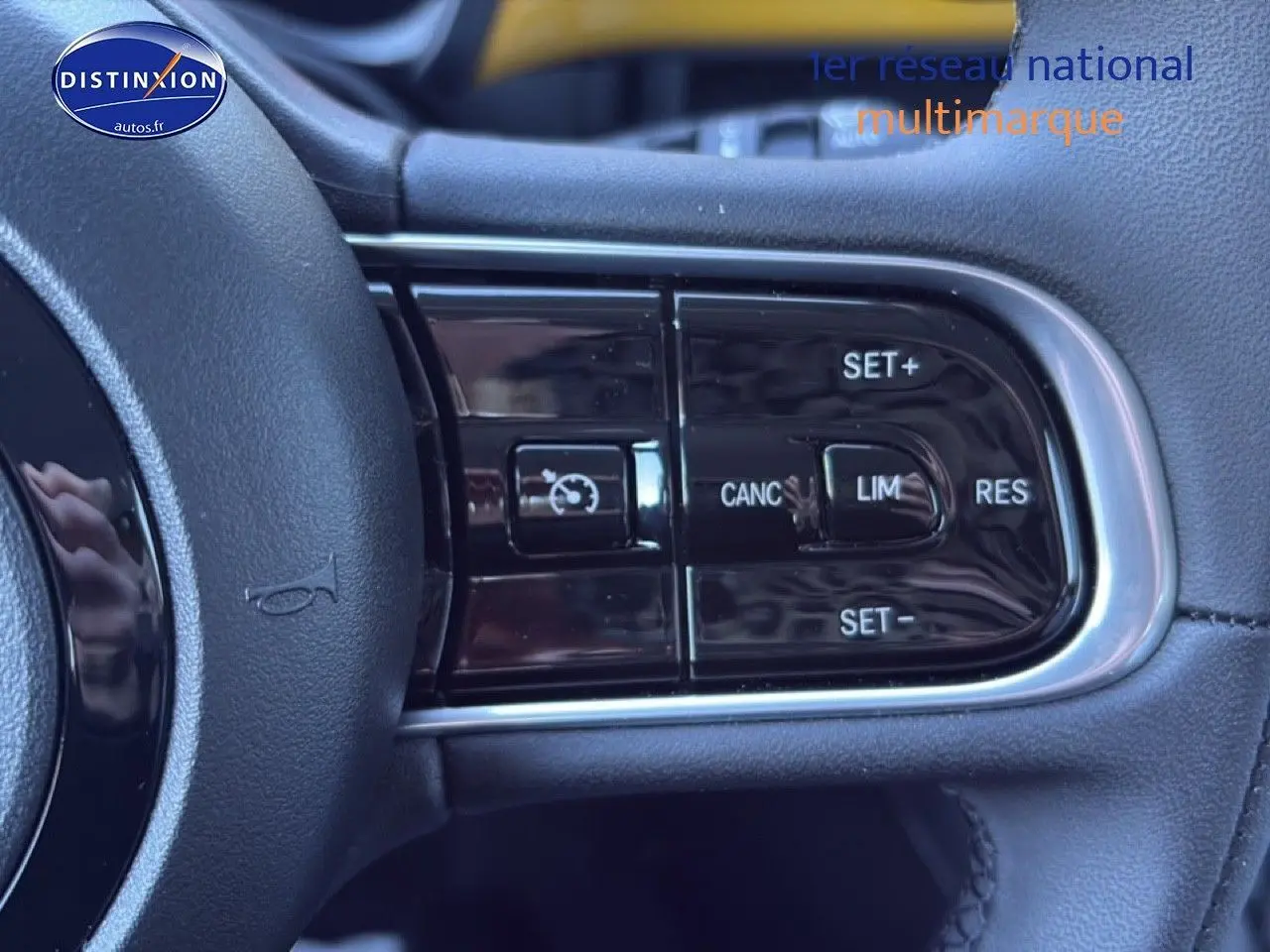 Gros plan sur les commandes multifonctions du volant côté gauche d'une Fiat 500 Yellow Gold Métal hybride 2026.