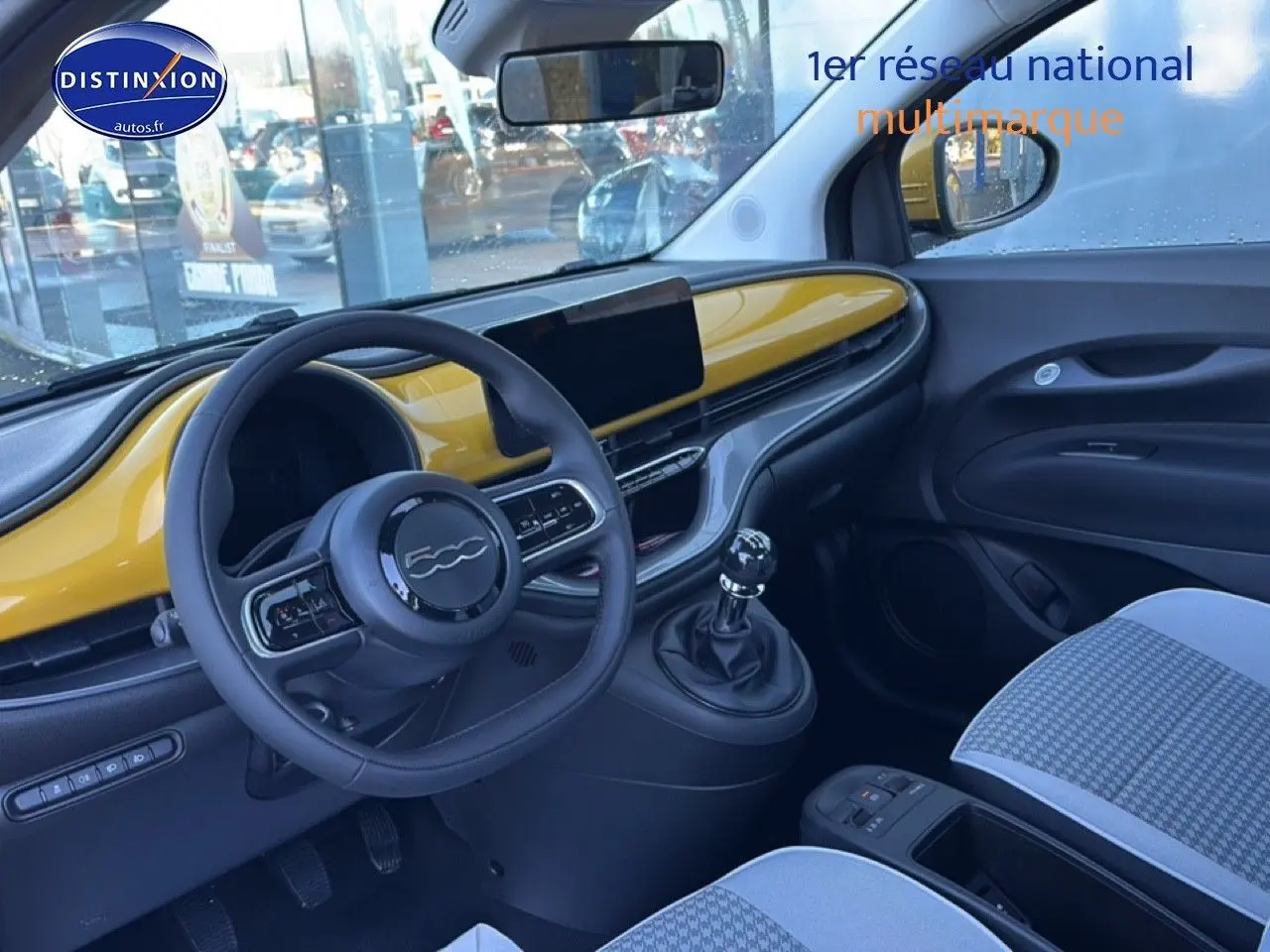 Vue intérieure côté conducteur de la FIAT 500 hybrid 2026 avec tableau de bord Yellow Gold Métal et motif pied de poule.