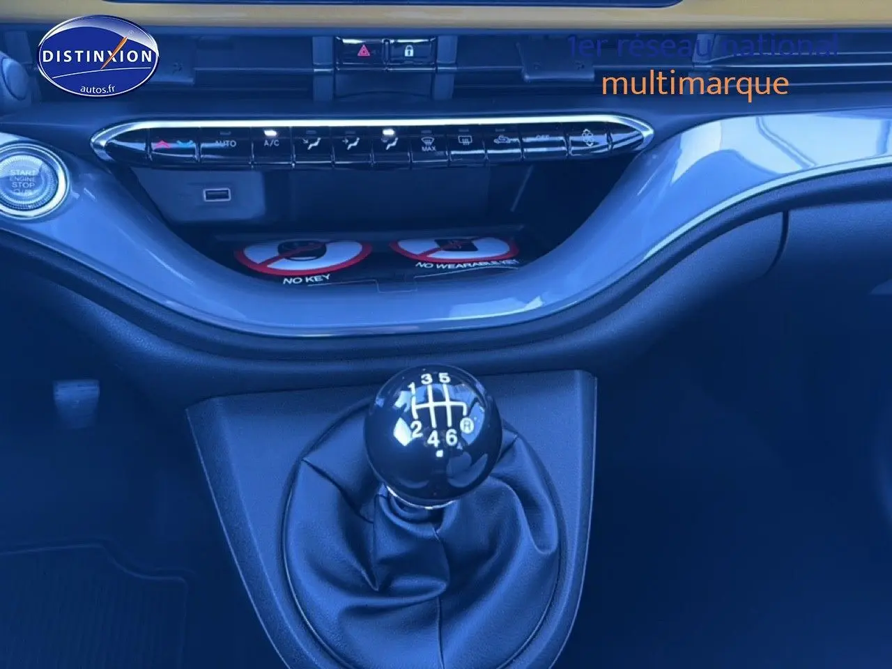 Gros plan sur la commande de boîte manuelle noire dans l'habitacle d'une FIAT 500 Yellow Gold Métal.