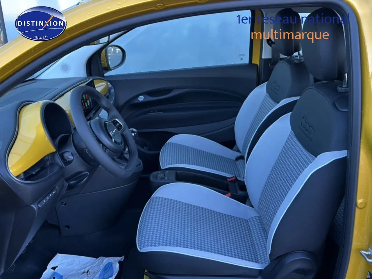 Vue intérieure côté conducteur de la Fiat 500 Yellow Gold Métal avec sièges à motif pied-de-poule et tableau de bord assorti.