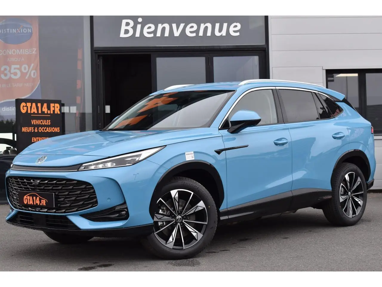 MG Motor EHS bleu métallisé en 3/4 avant droit, avec jantes alliage 19 pouces et vitres surteintées.