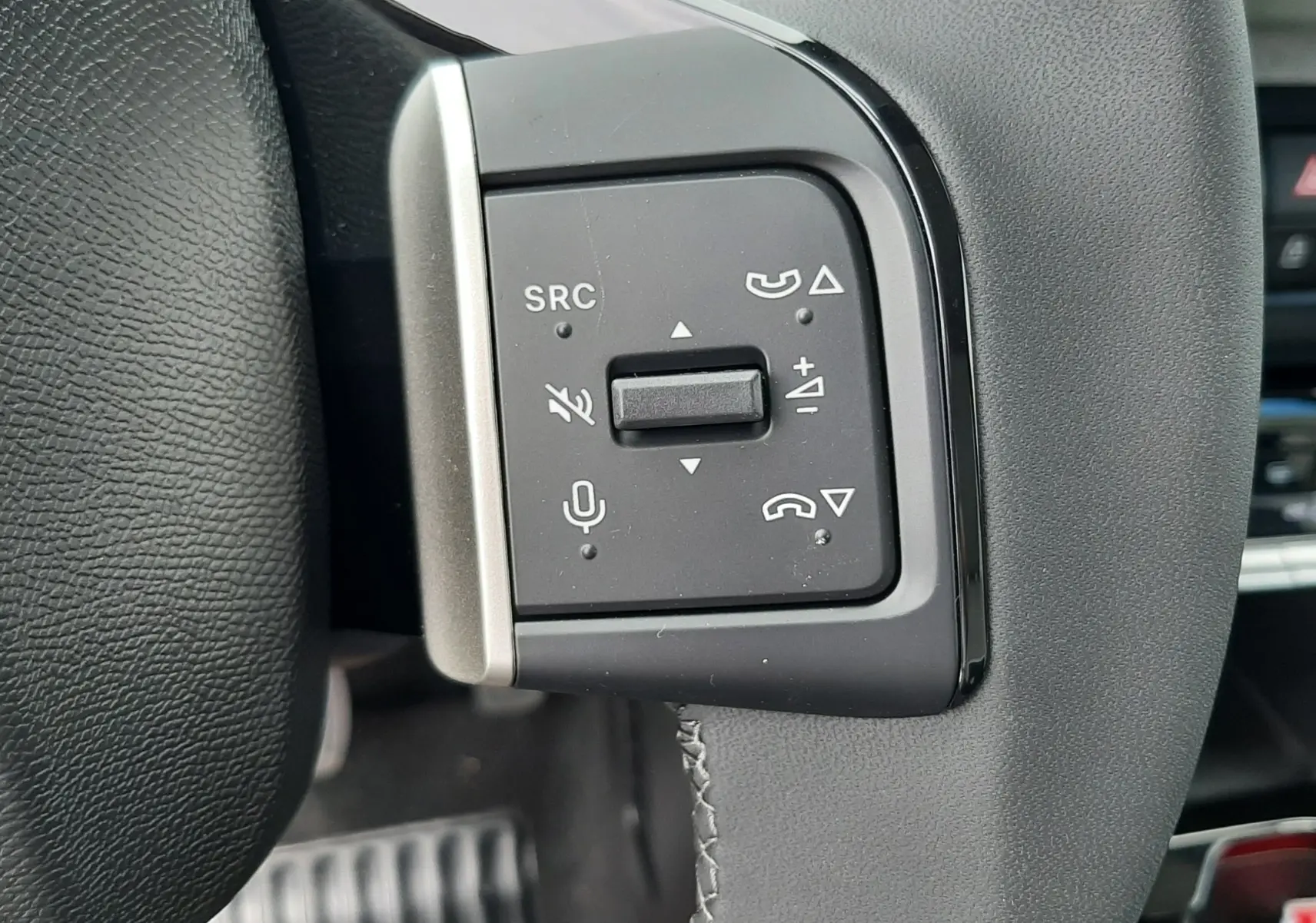 Gros plan sur les commandes au volant à gauche du Citroën C3 Aircross 2026, cuir noir avec surpiqûres grises.