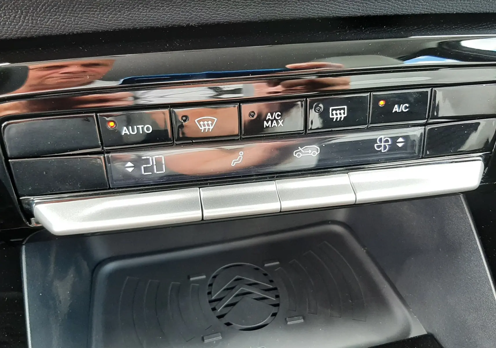 Gros plan sur la console centrale du Citroën C3 Aircross 2026, montrant les commandes de climatisation et le chargeur sans fil noir.