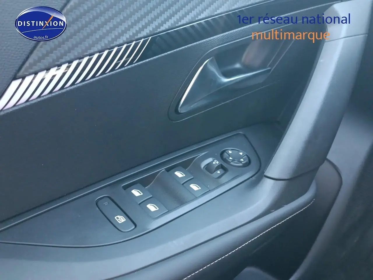 Détail de la commande des vitres électriques côté conducteur dans l'habitacle gris du Peugeot 2008 1.2 100 allure 2025.