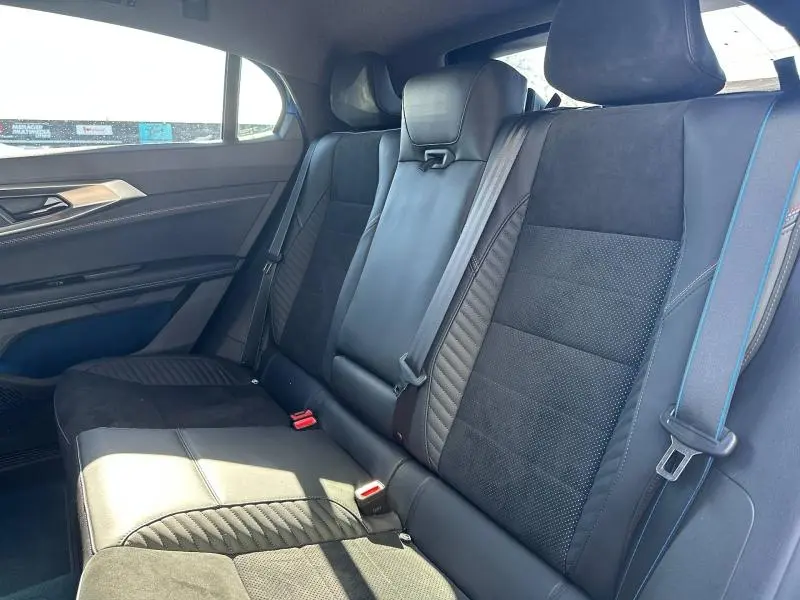 Vue intérieure des sièges arrière de la Renault Rafale 1.2 E-Tech bleu, avec sellerie mixte Alcantara et coutures bleues.