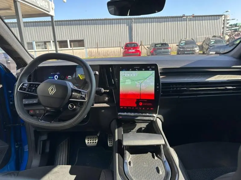Vue intérieure avant du Renault Rafale 2025 bleu sommet, avec tableau de bord numérique et grand écran tactile central.