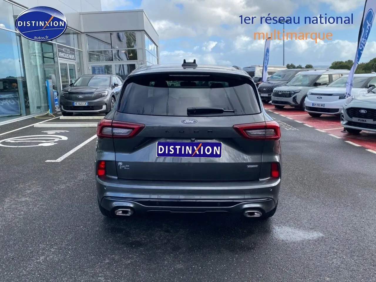 Vue arrière d'un Ford Kuga gris Magnetic Fashion Métallisée avec double sortie d'échappement et lunette arrière surteintée.