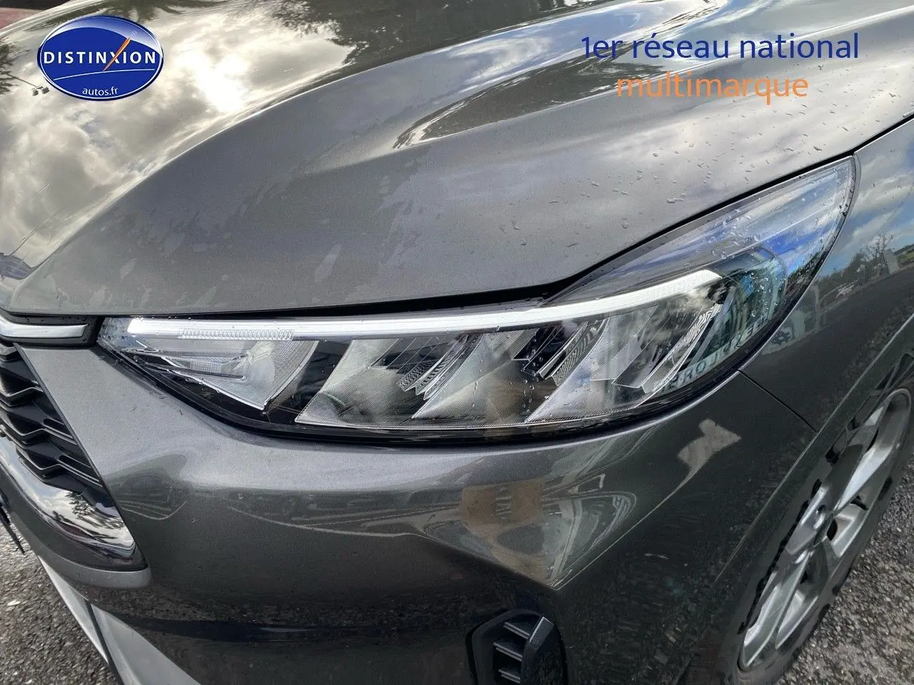 Gros plan sur le phare avant droit du Ford Kuga 2025 gris Magnetic Fashion métallisé avec jante alu visible.