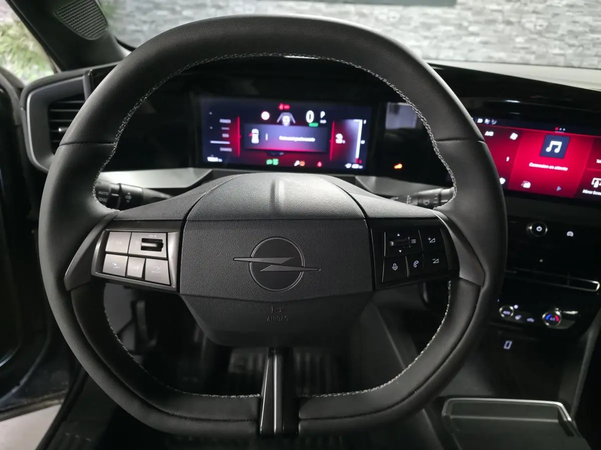 Vue centrée sur le volant noir de l'Opel Mokka-e 2025 avec tableau de bord digital et écran tactile.